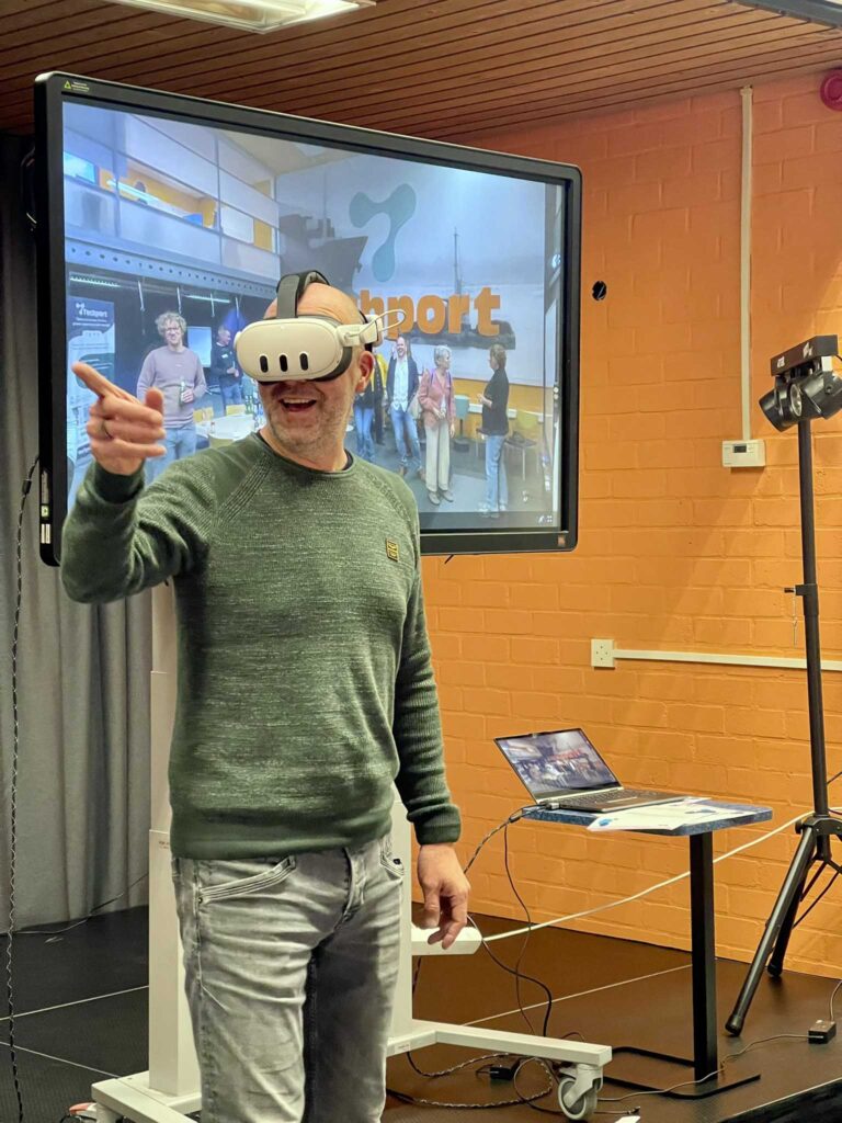 Docent met VR-bril wijst enthousiast tijdens een inspiratiesessie